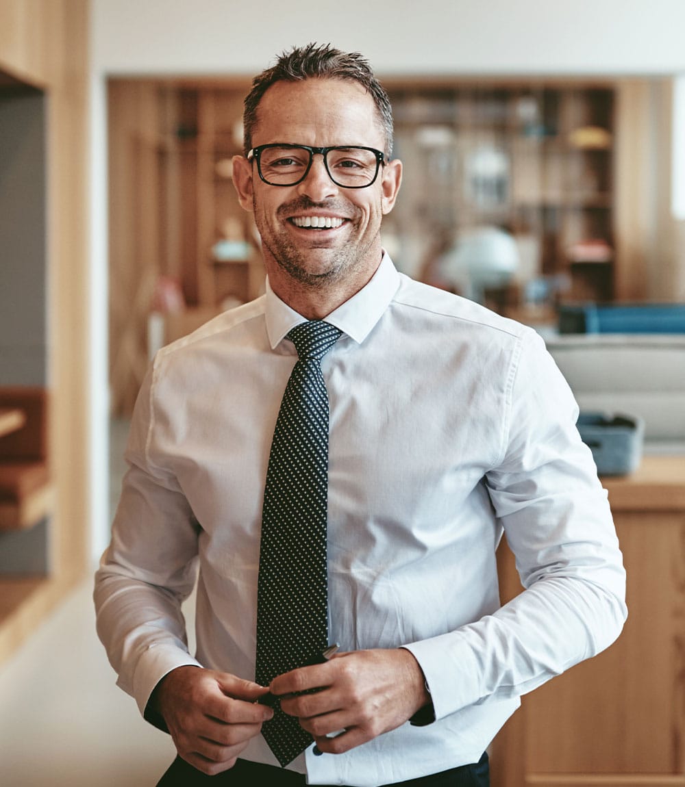 smiling mature businessman standing alone in an of GQBLE64